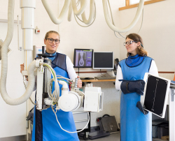 Mitarbeiterinnen einer Tierklinik zeigen Sicherheitsvorrichtungen im Röntgenbereich
