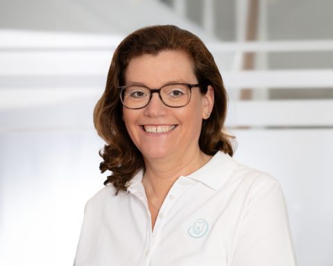 Portrait Zahnärztin, die in die Kamera schaut, in ihrer Praxis