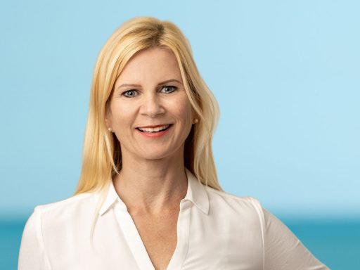 Freundliches Porträt Heilpraktikerin vor blauem Hintergrund