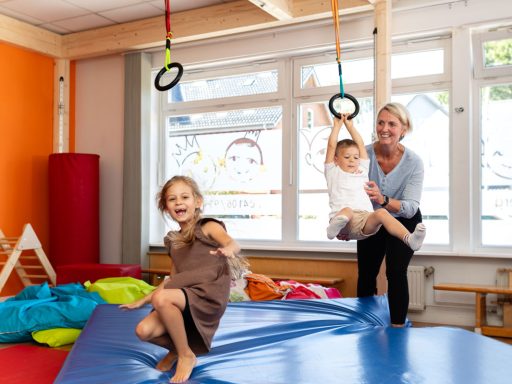 Zwei Kinder Bewegungstherapie mit Physiotherapeutin